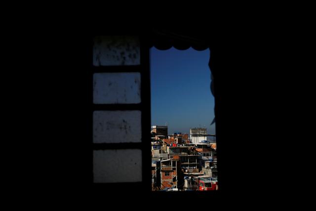Houses are seen through a window of Tiki hostel in Cantagalo favela. (REUTERS) 