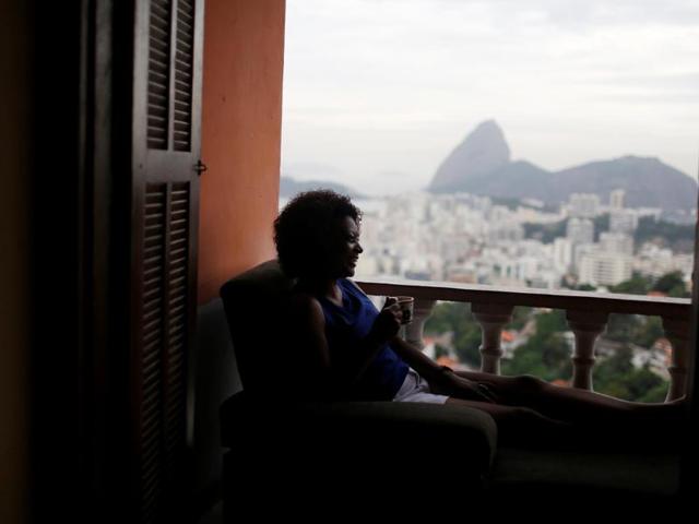 A guest relaxes with the The Sugar Loaf mountain in the background at Pousada Favelinha (Little favela) hostel. (REUTERS) 