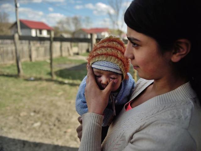 Diana, 15, holds her child at their home in a village near Botosani, north-eastern Romania. (AFP) Diana, 15, holds her child at their home in a village near Botosani, north-eastern Romania. (AFP)