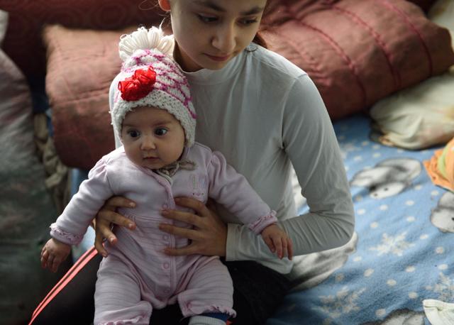 Lorena, 15, holds her child at her home in an abandoned building where another few families live in a village near Botosani, north-eastern Romania. (AFP) Lorena, 15, holds her child at her home in an abandoned building where another few families live in a village near Botosani, north-eastern Romania. (AFP)