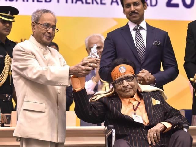 President Pranab Mukherjee shows a silver statue of Sai Baba gifted to him by veteran actor Manoj Kumar. The veteran actor was honoured with Dadasaheb Phalke Award at the 63rd National Film Awards 2015 function in New Delhi on Tuesday. (Ajay Aggarwal/HT Photo ) 
