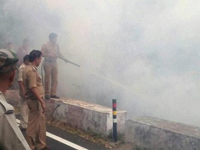 An army chopper carries water for extinguishing the fire in the forests at Kotdwar, Uttarakhand on Monday.(PTI)