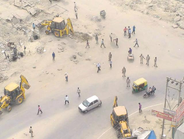 Residents said the local police came with bulldozers on Tuesday morning and razed the encroachments near highrises. (HT Photo) Residents said the local police came with bulldozers on Tuesday morning and razed the encroachments near highrises. (HT Photo)
