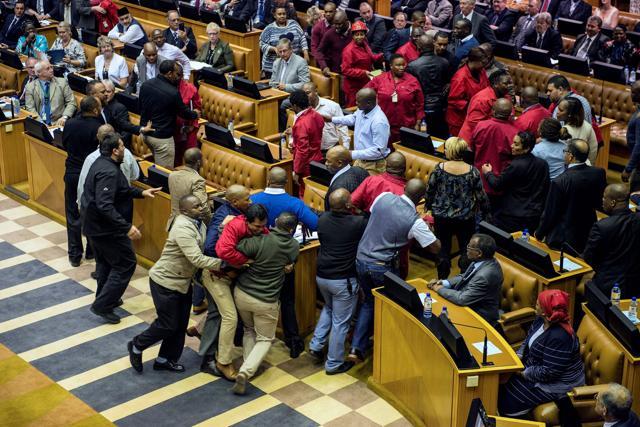 South African opposition party Economic Freedom Fighters MPs are pushed out of a parliament session during the South African president's budget speech in Cape Town on May 4, 2016. (AFP) South African opposition party Economic Freedom Fighters MPs are pushed out of a parliament session during the South African president's budget speech in Cape Town on May 4, 2016. (AFP)