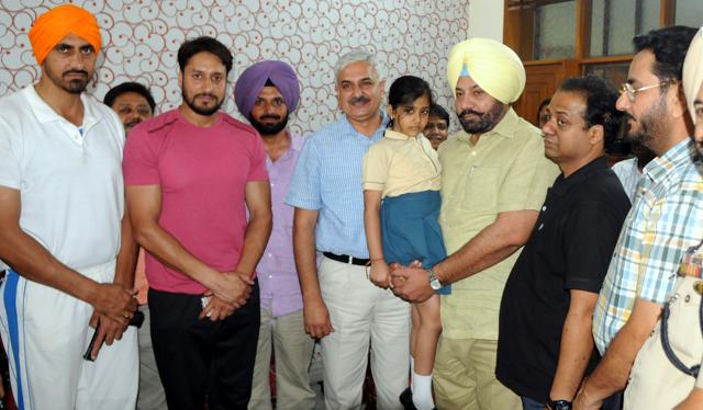 Patiala IGP PS Umranangal holding the girl after she was released, while his father (in black t-shirt) and others stand by, in Patiala on Wednesday (Bharat Bhushan/HT Photo) Patiala IGP PS Umranangal holding the girl after she was released, while his father (in black t-shirt) and others stand by, in Patiala on Wednesday (Bharat Bhushan/HT Photo)