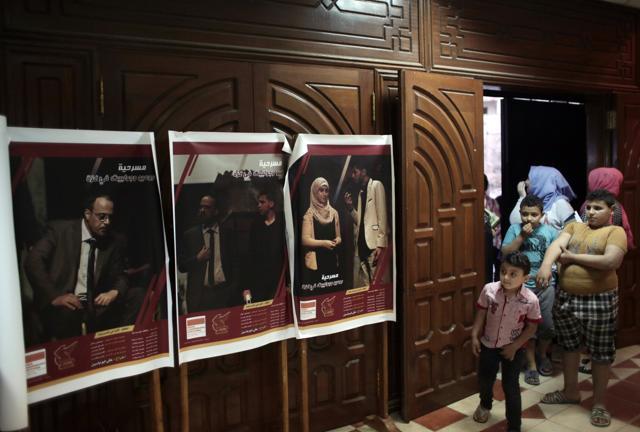 A Palestinian family looks at posters of the play. (AP) A Palestinian family looks at posters of the play. (AP)