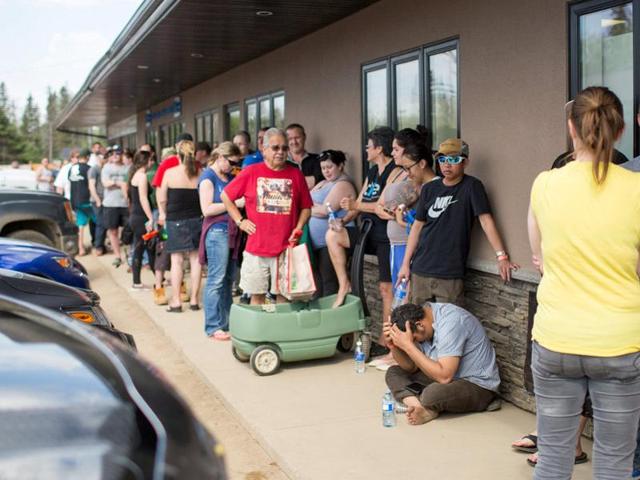 Residents of Fort McMurray line up outside a grocery store after they were ordered to be evacuated due to a raging wildfire, in Anzac, Alberta. (REUTERS)