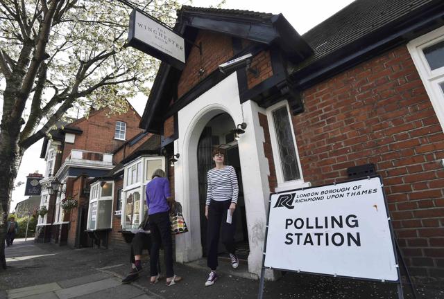 People walk past a pub being used as a polling station in west London, Britain, on Thursday. (REUTERS) People walk past a pub being used as a polling station in west London, Britain, on Thursday. (REUTERS)