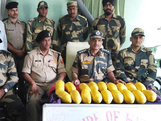 BSF officials with the seized heroin at Karnail Singh Wala border outpost in Tarn Taran district on Friday.(HT Photo)