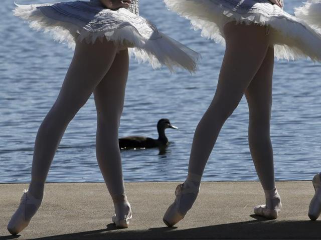 A duck paddles past the dancers in the nearby lake. (AP)