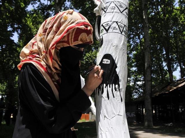 In Kashmir University, a group of around ten students of the music and fine arts department has turned a fallen chinar into an art installation featuring doodles, sketches and text.(Waseem Andrab/HT Photo)