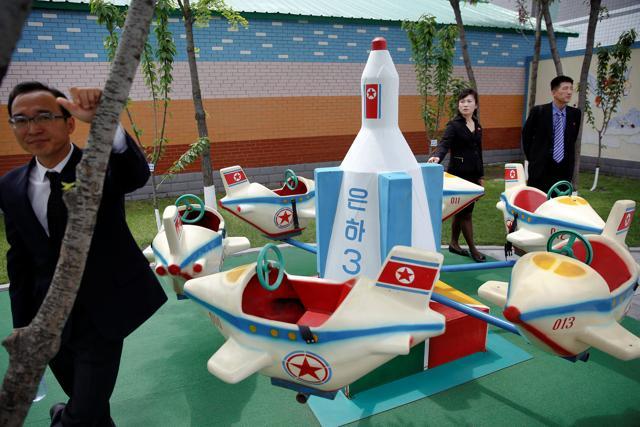 Officials accompanying foreign reporters stand near a rocked themed marry-go-around at kindergarden of a factory reporters visit on a government organised tour in central Pyongyang, North Korea May 9, 2016. (REUTERS)