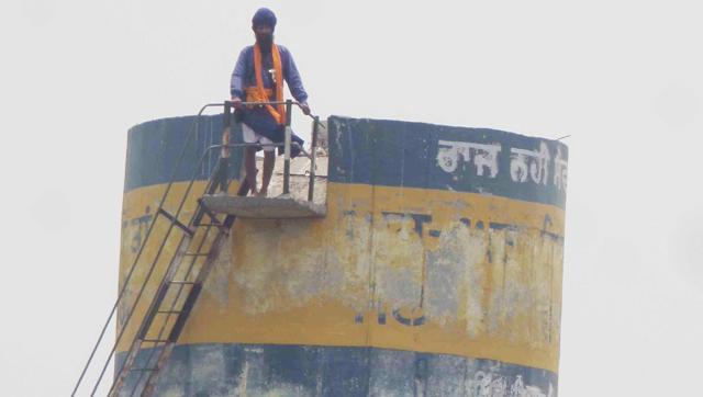 A Sikh activist climbs on water tank in protest against arrest of Dhian Singh Mand in Tarn Taran on Tuesday (HT Photo) A Sikh activist climbs on water tank in protest against arrest of Dhian Singh Mand in Tarn Taran on Tuesday (HT Photo)