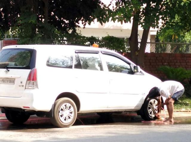 The driver of municipal corporation commissioner Anil Garg washing the latter’s official vehicle with a pipe outside his residence in Bathinda on Monday. (HT Photo) The driver of municipal corporation commissioner Anil Garg washing the latter’s official vehicle with a pipe outside his residence in Bathinda on Monday. (HT Photo)