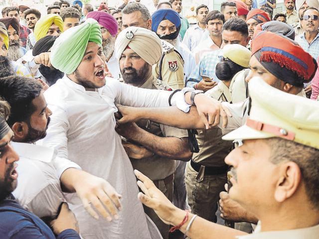 Police pushing the Team Insaaf members during a protest in Ludhiana on Monday.(JS Grewal/HT Photo)