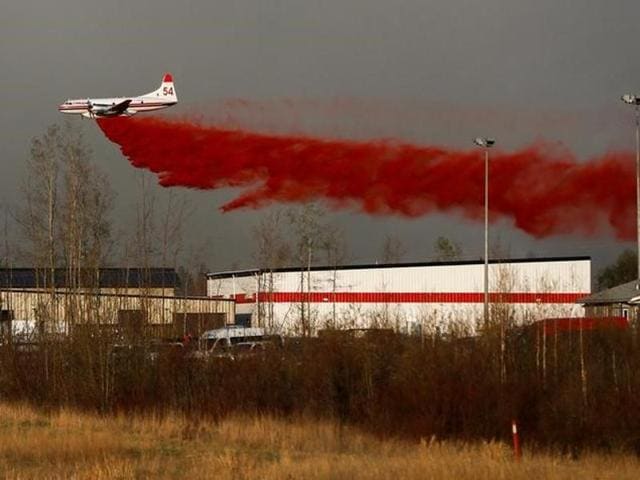 A plane flies low to dump fire retardant on wildfires near Fort McMurray, Alberta. (Reuters) A plane flies low to dump fire retardant on wildfires near Fort McMurray, Alberta. (Reuters)
