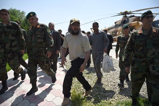 The son of former Pakistani prime minister Yousaf Raza Gilani, Ali Haider Gilani (C), is escorted by Afghan Special Forces personnel from an Afghan National Army helicopter at the Ministry of Defence in Kabul on May 11, 2016. (AFP)