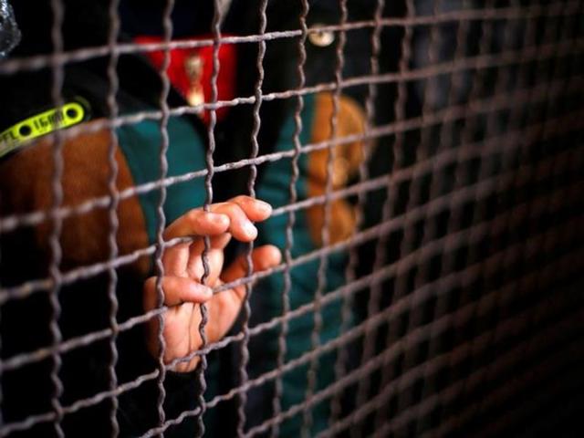 A boy stands behind a fence as he waits with his family for a travel permit to cross into Egypt through the Rafah border crossing on Tuesday. A boy stands behind a fence as he waits with his family for a travel permit to cross into Egypt through the Rafah border crossing on Tuesday.