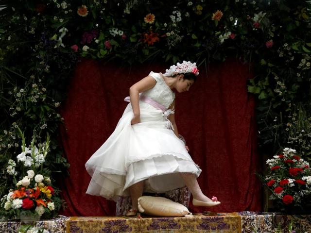 Young girls are chosen to become Mayas and sit at altars decorated with flowers so that people can admire them. Maya girl Lucia Carrillo, 12, leaves the altar for another Maya during Las Mayas festivity. (REUTERS)