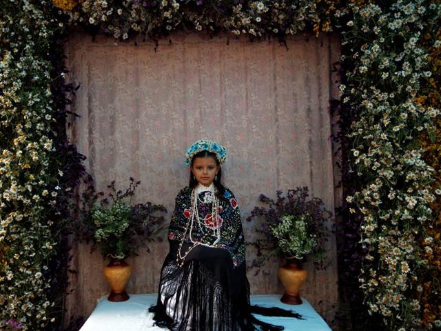 Maya girl Irene Garcia Sieteiglesias, 8, sits at an altar during Las Mayas festivity in Madrid, Spain, May 8, 2016. (REUTERS)