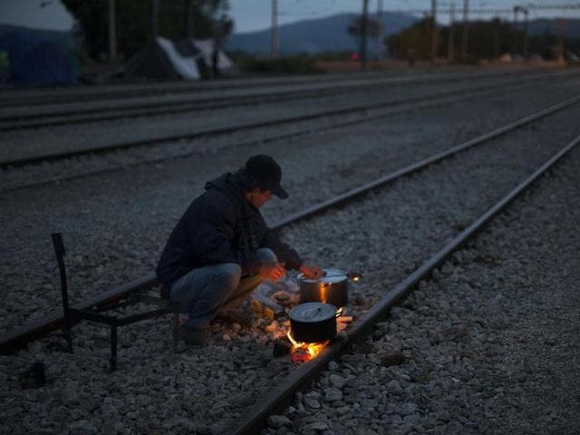 A man cooks on railway tracks at the northern Greek border point of Idomeni, Greece, on Tuesday May 10, 2016. (AP) A man cooks on railway tracks at the northern Greek border point of Idomeni, Greece, on Tuesday May 10, 2016. (AP)