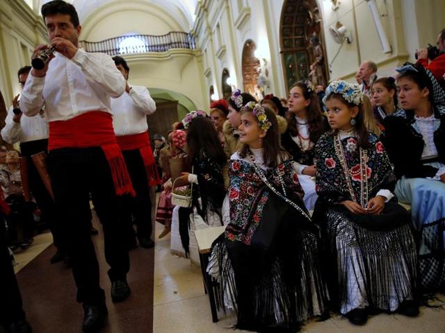 Musicians sing their praises and tell about their beauty while people dance and Maya girl assistants request money in exchange for sweets and flowers. Maya girls and their assistants look at musicians playing at San Lorenzo church during Las Mayas festivity. (REUTERS)