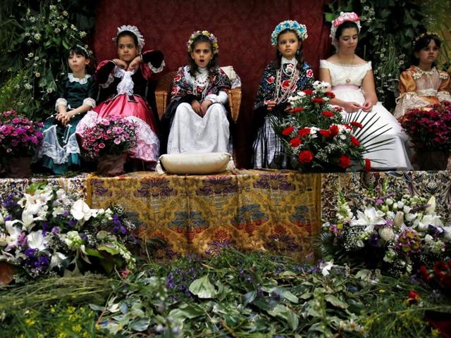 After spending a couple of hours sitting still at the altars, the Mayas and their assistants carry out a floral offering to the Virgin at San Lorenzo Church. Maya girls sit at an altar. (REUTERS)