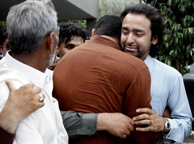 FILE - In this Thursday, May 9, 2013 file photo, People comfort Musa Gilani, right, the brother of Ali Haider Gilani who was kidnapped in Multan, Pakistan. (AP)