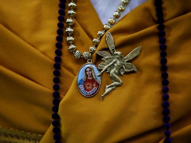 The Mayas are dressed in traditional costumes, often displaying shawls and a wreath of flowers on their heads. Maya assistant girl Lara Ibarra, 12, wears a medallion of the Virgin. (REUTERS)