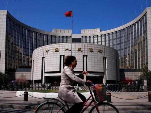 A woman rides past the headquarters of the People’s Bank of China, the central bank, in Beijing. (Reuters) A woman rides past the headquarters of the People’s Bank of China, the central bank, in Beijing. (Reuters)