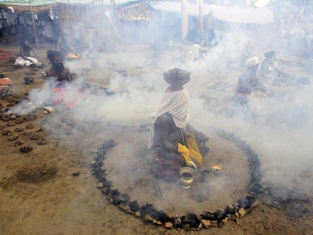 Sadhus offer prayers while sitting inside circles of burning "Upale" (or dried cow dung cakes) during a prayer ceremony at the Simhastha Kumbh Mela in Ujjain. (REUTERS) 