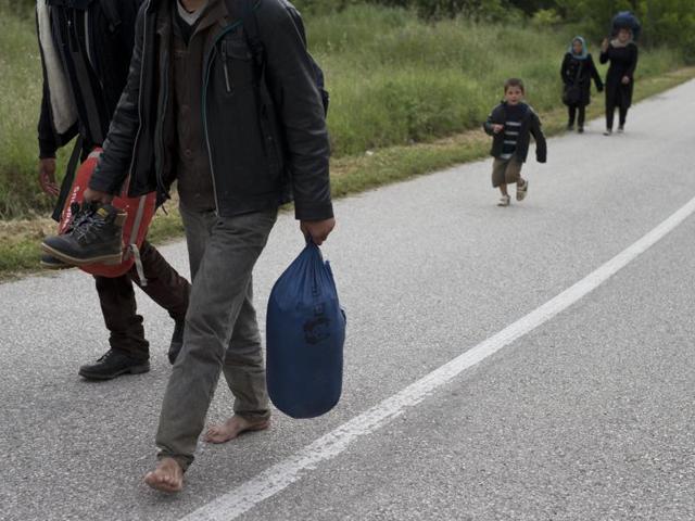 A family walks to Idomeni camp, Greece, after a group of migrants and refugees tried to cross the Macedonia's border on Wednesday. (AP) A family walks to Idomeni camp, Greece, after a group of migrants and refugees tried to cross the Macedonia's border on Wednesday. (AP)