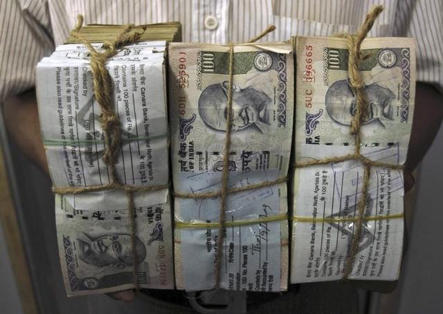 An employee carries bundles of Indian currency notes inside a bank in Agartala, capital of Tripura, October 26, 2009.(Reuters)
