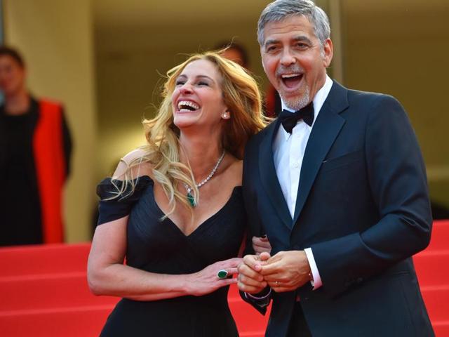 Julia Roberts with George Clooney as they arrive for the screening of the film Money Monster at the 69th Cannes Film Festival.(AFP)