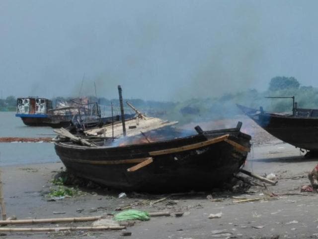 One of the vessels set afire by local residents, who were angered by the delay in launching rescue operations after a boat capsize in Nadia on Saturday night.(HT Photo)