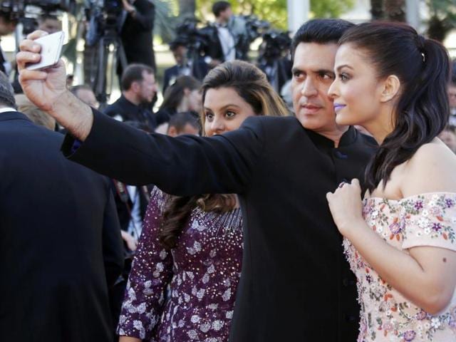 Actor Aishwarya Rai Bachchan (Right) takes a selfie as she poses on the red carpet as she arrives for the screening of the film Mal de pierres with Sarbjit director Omung Kumar . (REUTERS) 