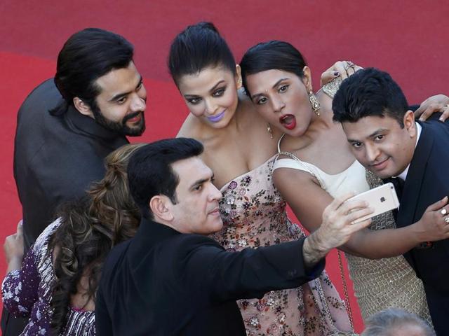 Actress Aishwarya Rai Bachchan takes a selfie with the Sarbjit team as she arrives on red carpet for the screening of the film Mal de pierres (From the Land of the Moon) in competition at the 69th Cannes Film Festival in Cannes. (REUTERS)
