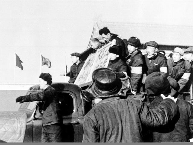 Two men with placards around their necks are declared anti-revolutionary elements and paraded through the streets of Beijing by members of the Red Guard during the early days of the Cultural Revolution. (AP File Photo)