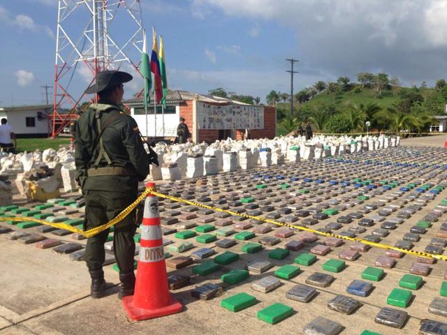 A Colombian national policeman stands guard in front of packages of cocaine, which were confiscated in Turbo province near the border with Panama, May 15, 2016. (REUTERS)