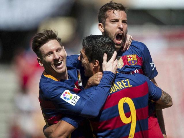 Barcelona's Luis Suarez, center, celebrates scoring against Granada with teammates Lionel Messi, left, and Jordi Alba during the match against Granada, which sealed Barca’s La Liga win. (AP)