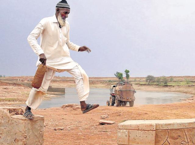 Caretaker Mohammed Akbar takes a round of the pond as a tanker takes water at Kumhari village. (HT Photo/Himanshu Vyas) Caretaker Mohammed Akbar takes a round of the pond as a tanker takes water at Kumhari village. (HT Photo/Himanshu Vyas)