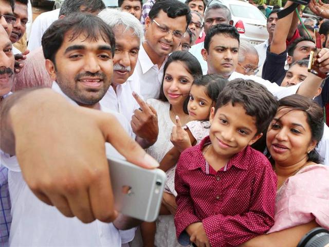 Kerala chief minister Oommen Chandy -- with family -- gets a selfie clicked outside a polling station after casting his vote for the Kerala assembly elections in Kottayam district on Monday. (PTI) Kerala chief minister Oommen Chandy -- with family -- gets a selfie clicked outside a polling station after casting his vote for the Kerala assembly elections in Kottayam district on Monday. (PTI)