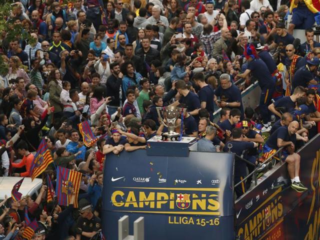 FC Barcelona’s players interact with the crowd as the bus passes. (AP)