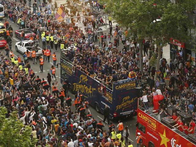 The open-top bus carrying Barcelona’s players passes through the streets of the city. (AP)