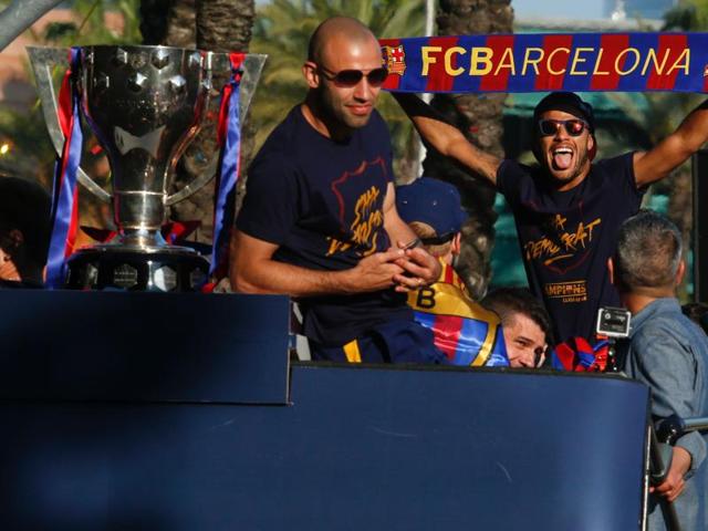 Barcelona's Javier Mascherano (L) and Neymar parade on a bus with their teammates through the streets of Barcelona to celebrate FC Barcelona's 24th La Liga title, in Barcelona, on May 15, 2016. (AFP)