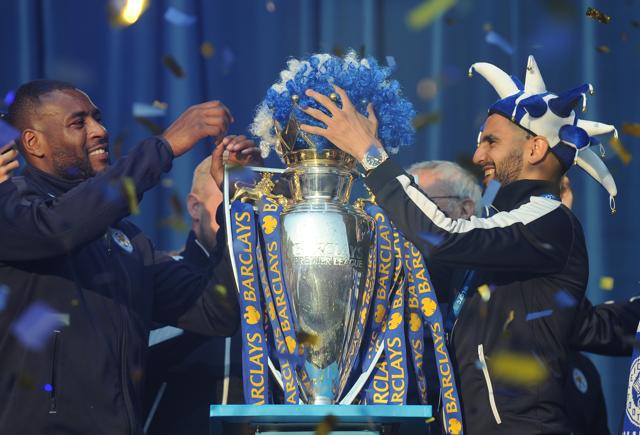 Leicester City captain Wes Morgan, left, and Riyad Mahrez place a wig in club colours on the Premier League Trophy at Victoria Park during the victory parade. (AP) Leicester City captain Wes Morgan, left, and Riyad Mahrez place a wig in club colours on the Premier League Trophy at Victoria Park during the victory parade. (AP)