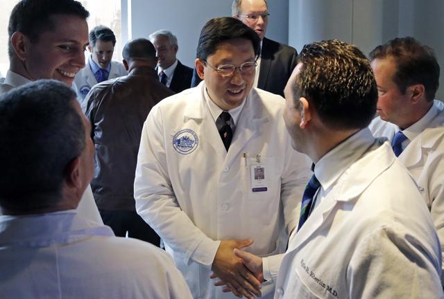 Dr. Dicken Ko, director of Massachusetts General Hospital's urology program, shakes hands with surgical team members after a news conference at the hospital. (AP Photo)