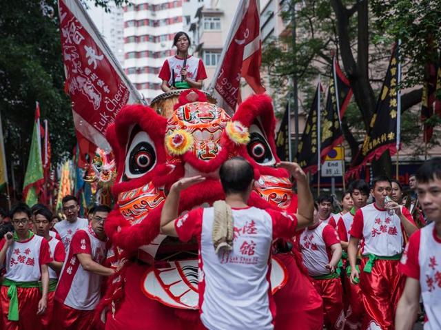 A performer plays the drums atop a dragon float during a street parade to celebrate the birthday of sea deity Tam Kung in Hong Kong on May 14, 2016. (AFP) 