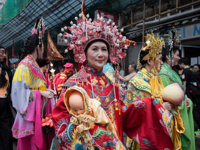 Performers wearing traditional costumes take part in a street parade to celebrate the birthday of sea deity Tam Kung in Hong Kong on May 14, 2016.  (AFP) 
