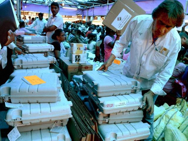 Election materials and Electronic Voting Machines (EVMs) being distributed among polling officers before the first phase of assembly elections in Tezpur, Assam. (PTI Photo)